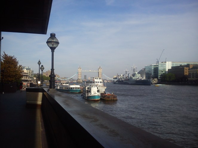 The Thames north bank in early evening. In the distance, Tower Bridge and just to the right, the WWII light-cruiser HMS Belfast